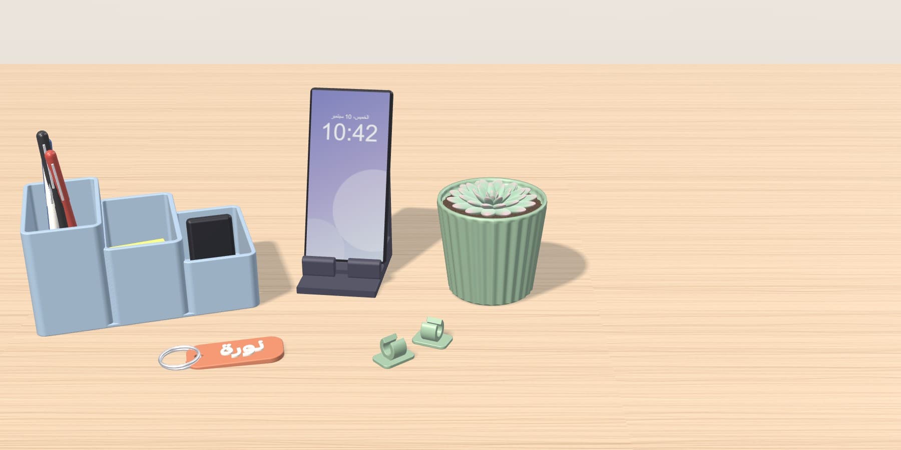 Illustrative 3D render of a desk organiser, phone stand, planter, keychain and cable clips on a desk.